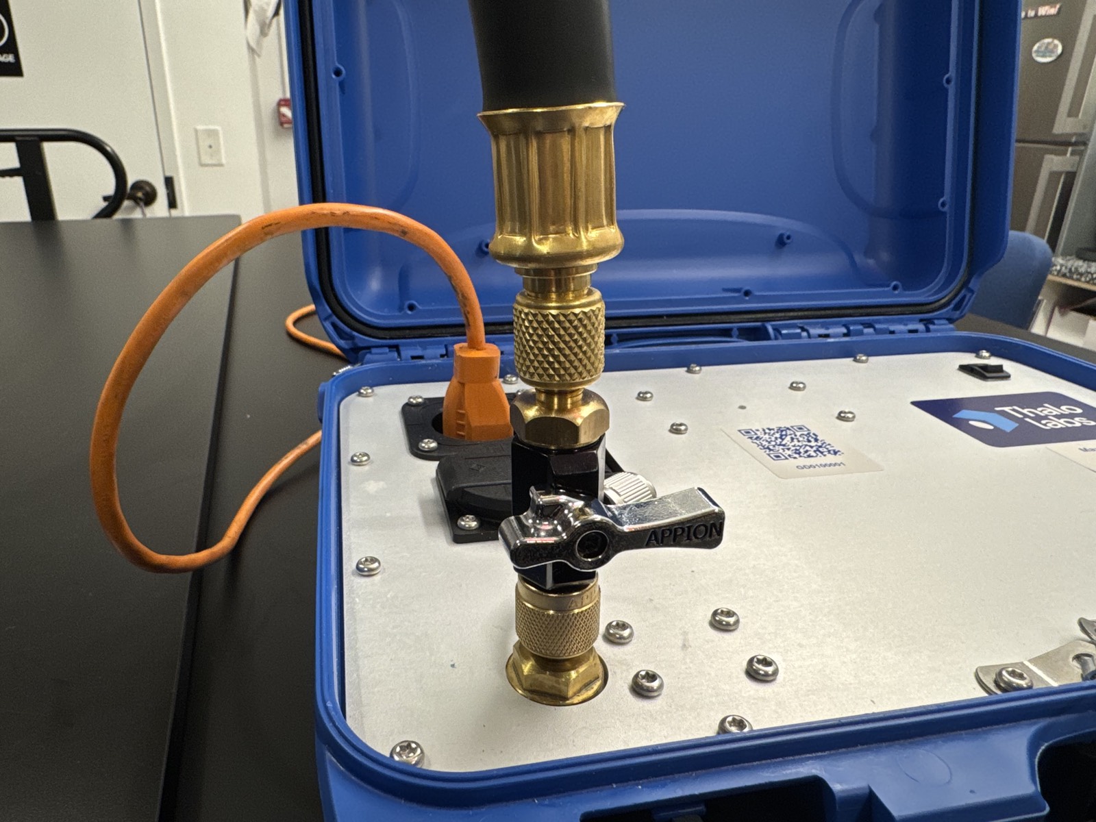 Brass core removal tool with its valve lever, attached upright to Gordon's left source port with a black hose running up from it